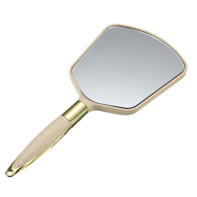 Square handheld makeup mirror in beige by BeautyNomix, lightweight design for easy portability.